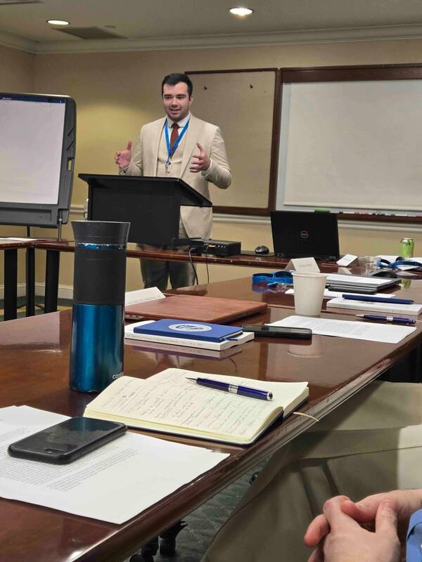 man in tan suit presenting