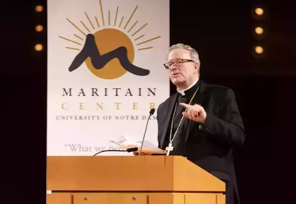 Bishop Barron at a podium with the Maritain Center banner in the background