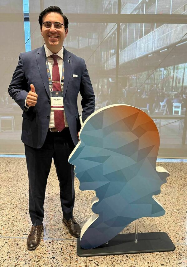 Caplan standing next to Federalist Society Image