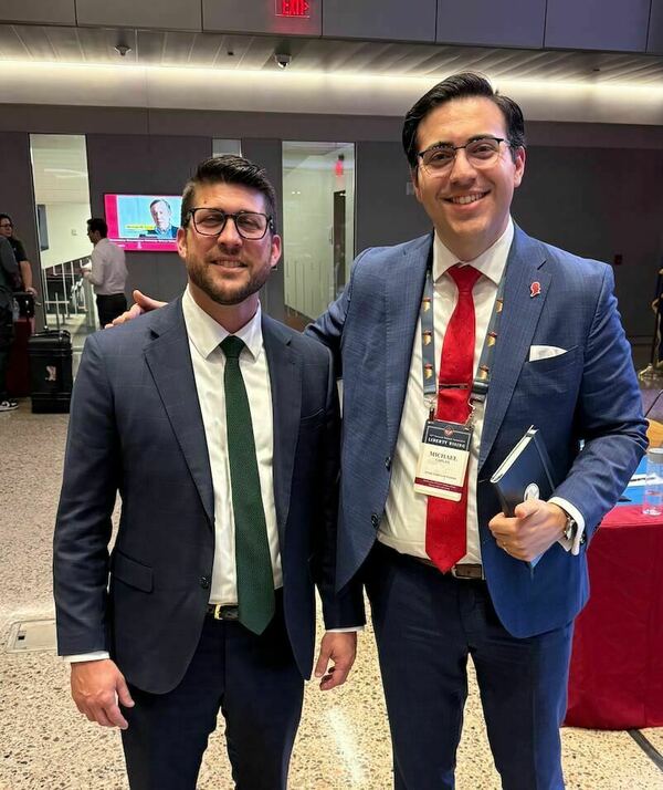 Man with Green tie standing with man with red tie