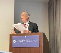 Man in gray suit speaks at conference