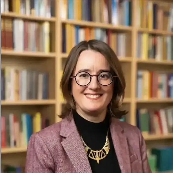 Woman with brown hair and glasses, smiling